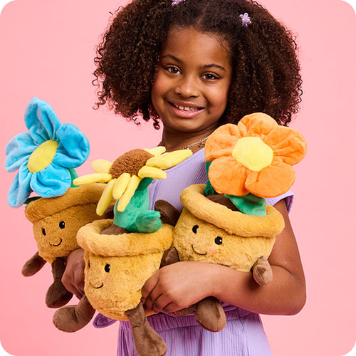 Image 100: girl holding three flower pot stuffed animal warmies