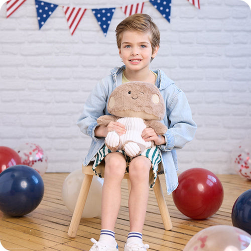 Image 107: boy holding brown mushroom stuffed animal warmies